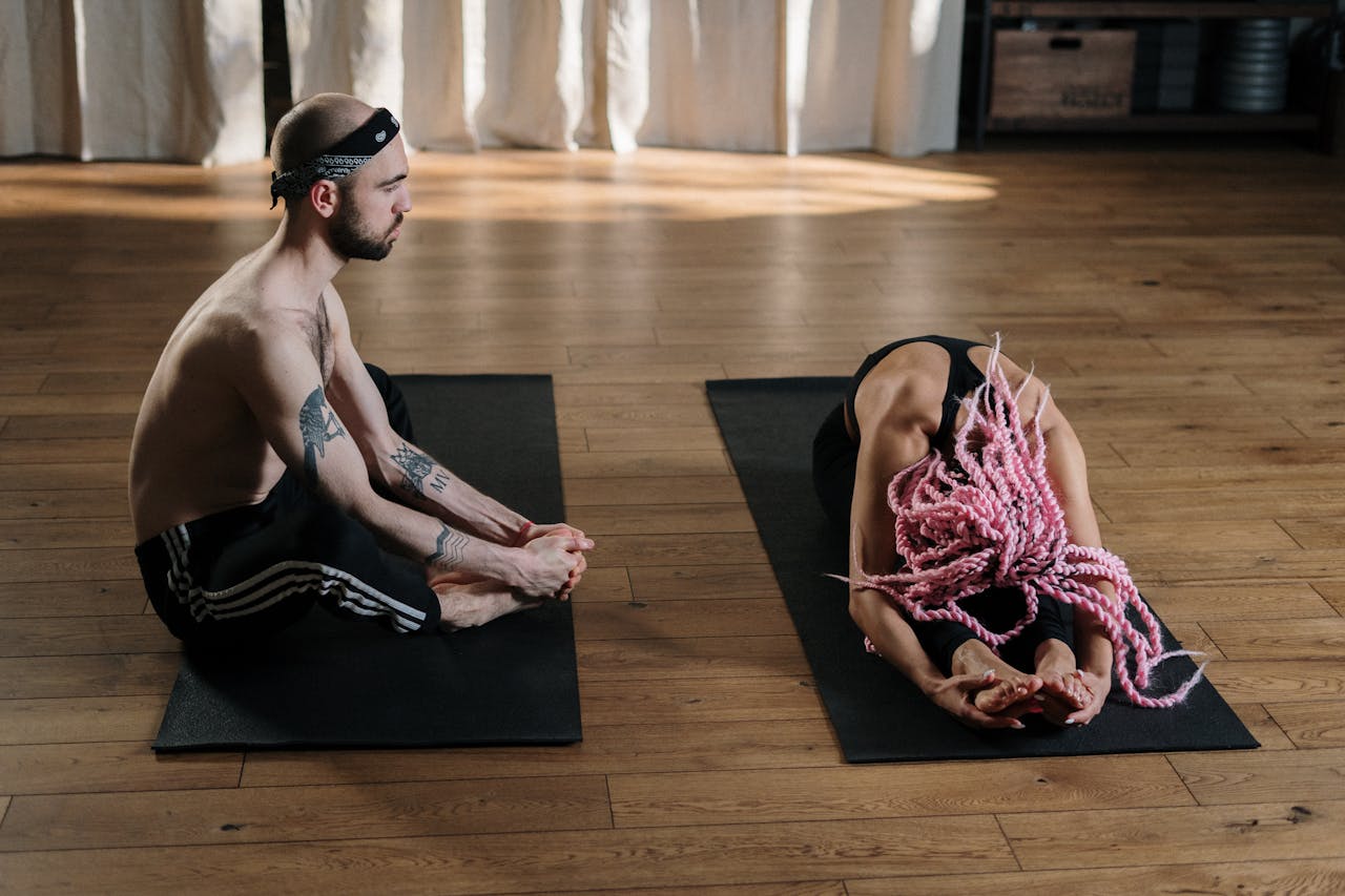 Two people practicing yoga in a studio, enhancing wellness and flexibility.